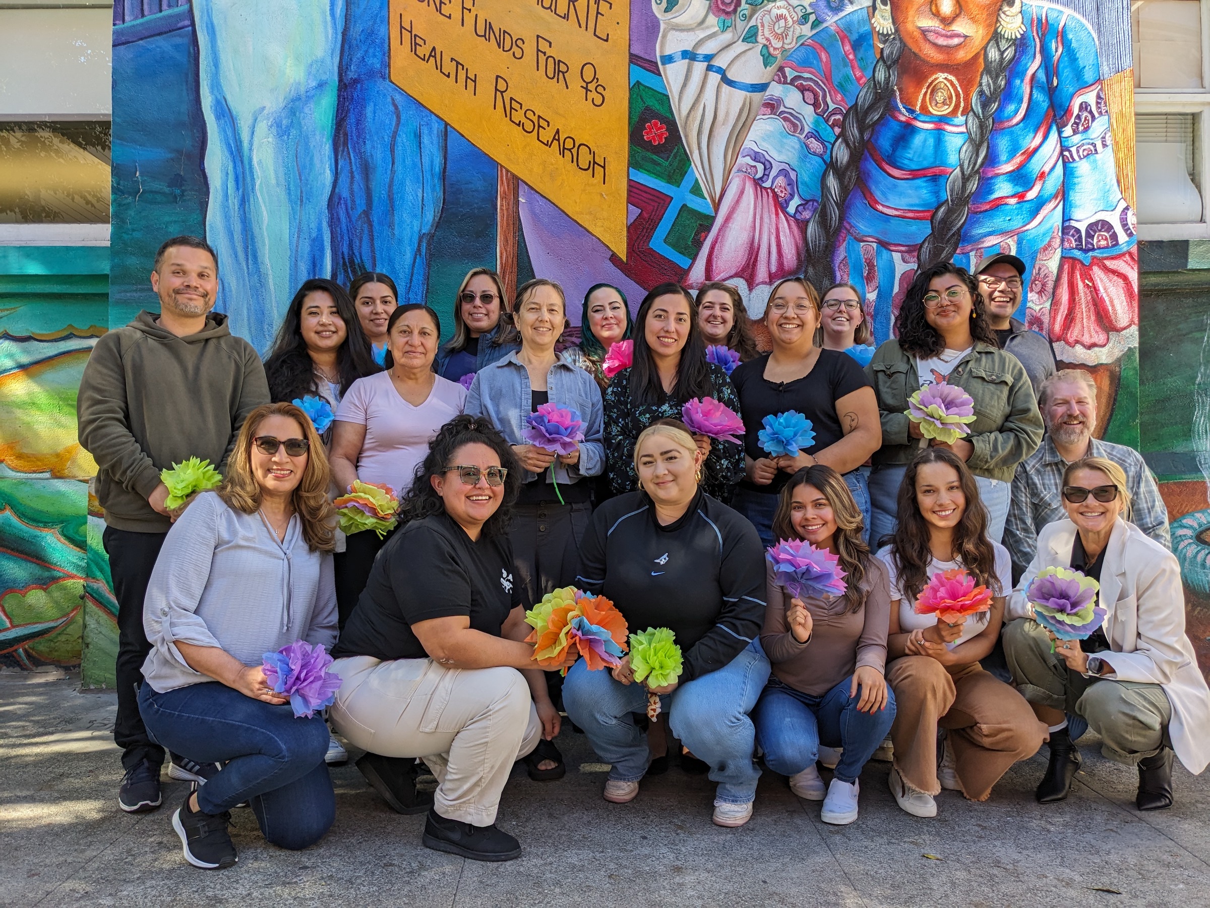 Group photo of staff with Women's Building Mural in the background. 